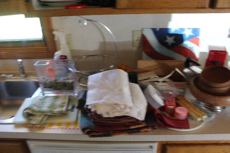 lot 28 image: Counter Lot of Housewares Includes Placemats, Regal Electric Knife, Wood Bowls, Cutting Boards