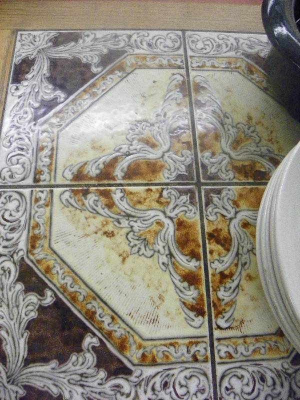 lot 90 image: Table with tile inlay 46 x 26 x 31 tall, includes all the kitchen wares sitting on it See pictures