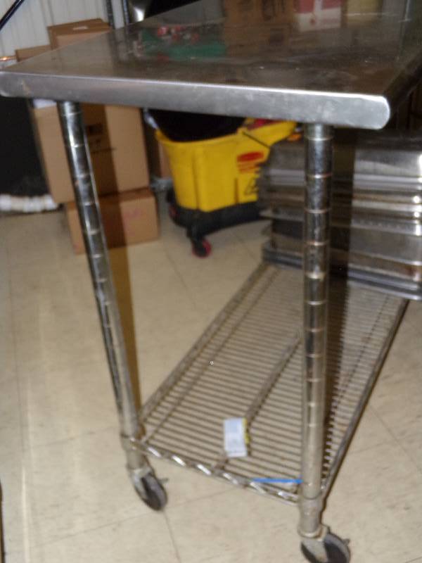 lot 237 image: Stainless steel tablework space on wheels. 50 x 24 x 40 tall. Contents of lower shelf not included.