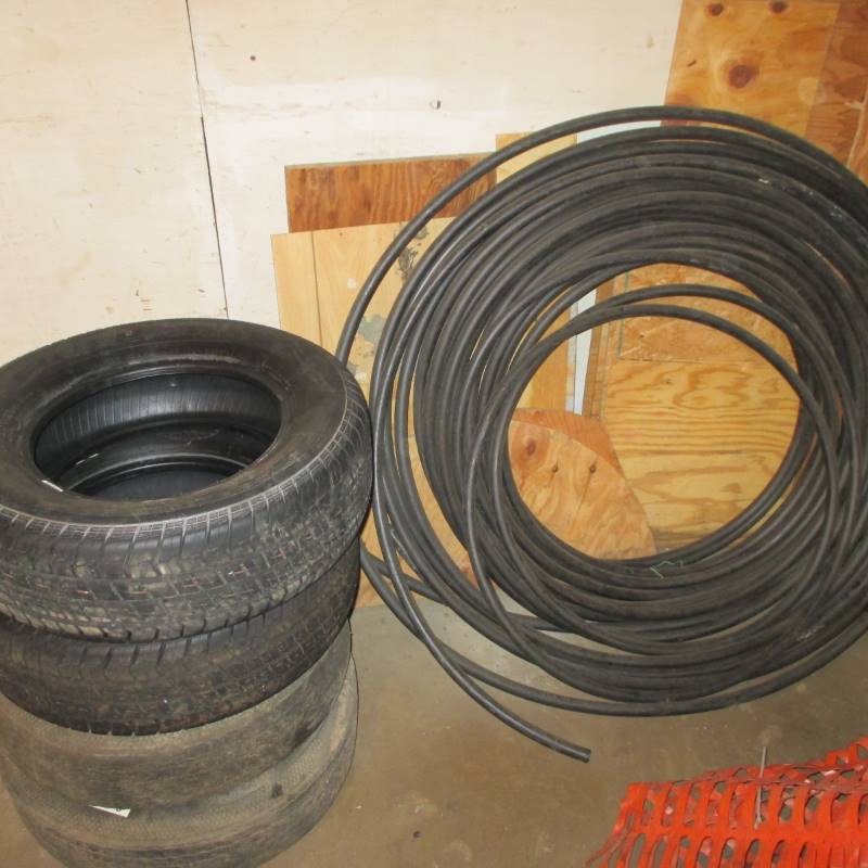 lot 34 image: (4) Tires 2-New 2-Used, Plastic Pipe, Plywood