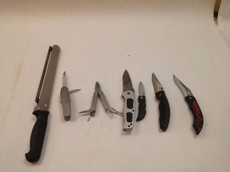 lot 837 image: Lot of 7 Various Knives Montana Adjustable Bread  Meat Slicing Knife, Grey Frost Flip Knife, (2) Apache Black Stainless Flip Knife, Generic Multi-tool Knife, Generic Multi-tool with American Eagle, Frost Barracuda Flip Knife