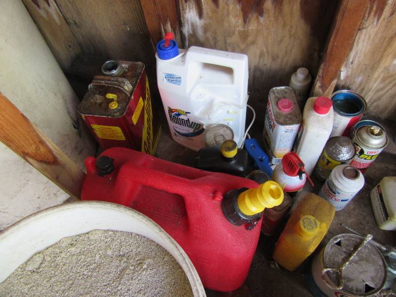 lot 195 image: Misc. Oils, Liquids as shown in the garage.. 2 gas cans,, 2 pails of some type of soilsand.. Take it if you want it.
