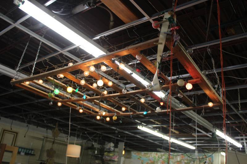 lot 201 image: 1920s box spring frame with vintage bulb lights.