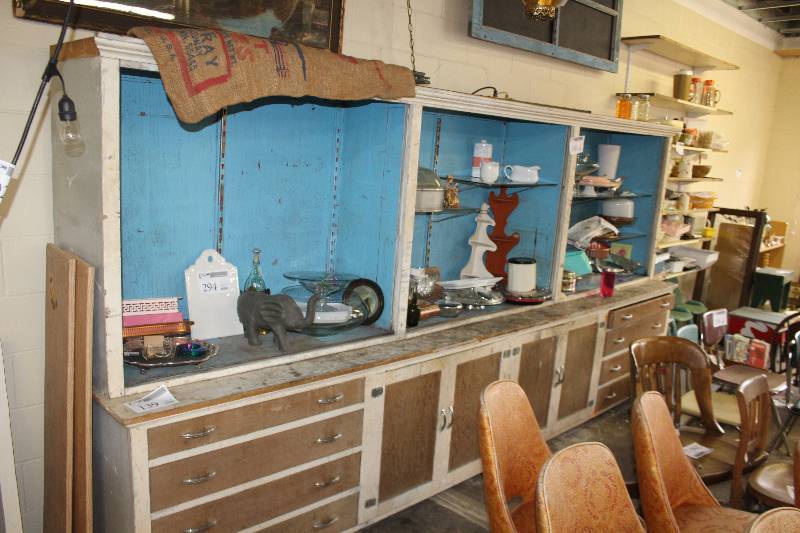 lot 139 image: Vintage mercantile display piece. 12 feet long and solid. All drawers in working order. Glass shelving included.