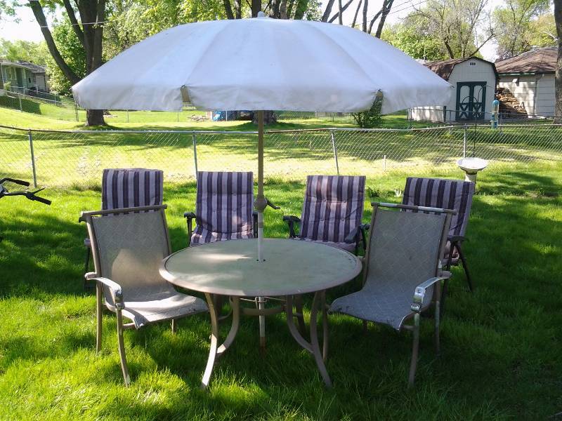 lot 77 image: 48 Inch Glass Top Table With Umbrella (With Cast Iron Base), 6 Assorted Chairs Need Power Wash & Little Bit Of Love