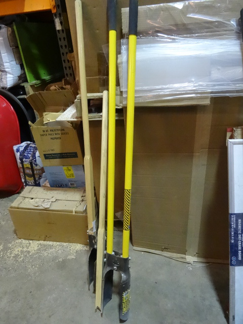lot 181 image: NEW LOT Qty 2 Post Hole Diggers  1 wood handle with cracked handle and 1 fiberglass with minor tear to handle covers at top. Retail $100