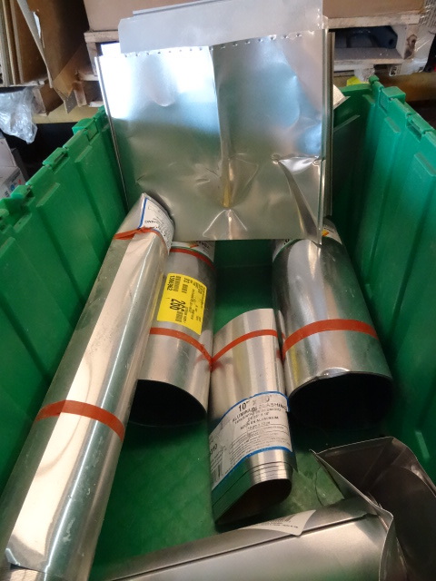 lot 7 image: NEW LOT METAL FLASHING 4 Rolls flashing, 2 galvanized , 2 aluminum, misc flashing pieces. All flashing in the bin. Scratch and dent. Please inspect GREEN BIN NOT INCLUDED