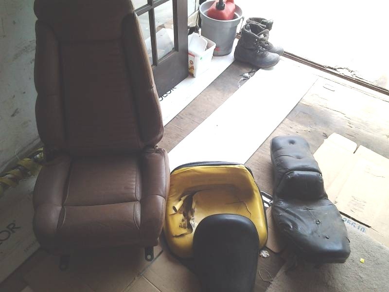 lot 145 image: Buick Reatta Leather Tan Seat, J.D. Mower Seat, 2-Motor Cycle Seats