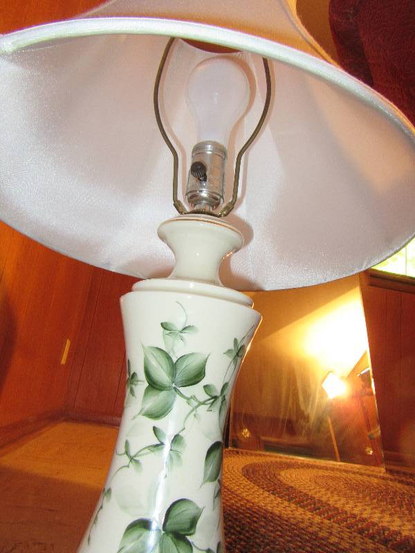 lot 165 image: 2 nice table lamps.. 1, cedar hand made  1 nice porcelain with green floral dcor.. Nice shades
