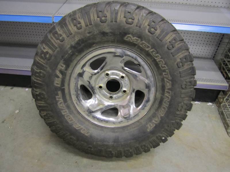 lot 212 image: Large truck tire and rim. Dick Cepe...