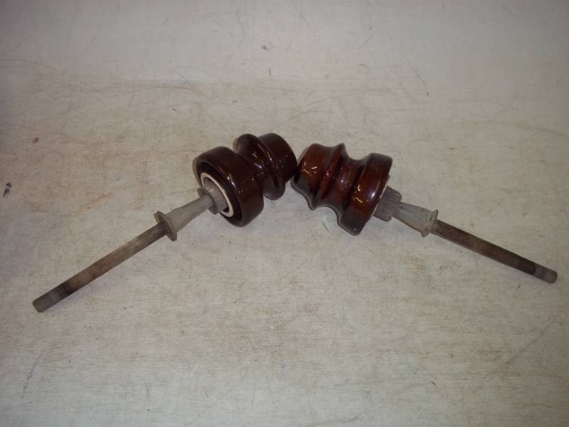 lot 10 image: 2 different Brown Ceramic insulators with bolt & stake attached.