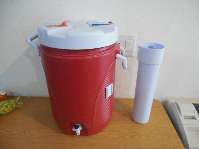 lot 21 image: Rubbermaid 5 Gal. Modern Red Cooler with Cup Dispenser