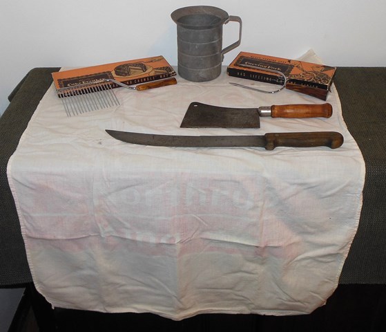 lot 150 image: Vintage Weck & Muller Knife, Rev-o-noc Butcher Knife, Aluminum Pitcher, Brome Grass Northrup King Dish Towel, Langner Mfg. Co. Hostess Cake Breaker and Host Carving Fork