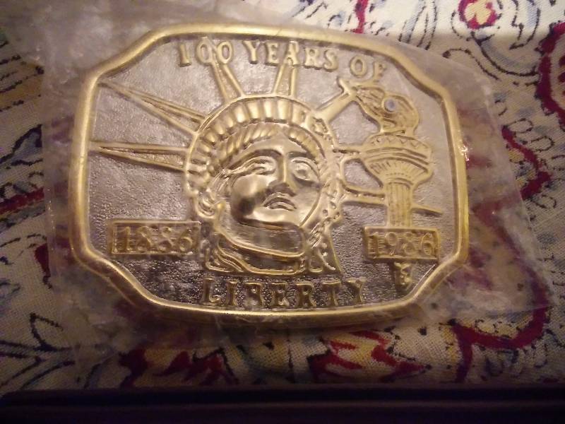 lot 11 image: Assorted Belt Buckles (4) American Historical, ND Miss Rodeo, Statue of Liberty, Fathers Day