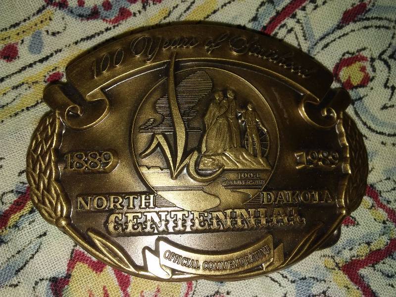 lot 12 image: Assorted Belt Buckles (5) GTA Feed, Casselton, Clack, Statue of Liberty, ND Centennial
