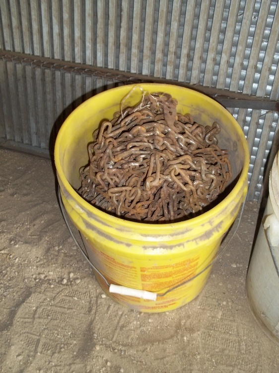 lot 211 image: Yellow 5 gal pail containing car tire chains