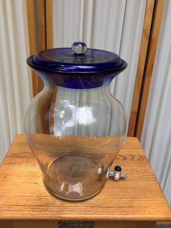 lot 25 image: Beautiful Artisan Made Blown Art Glass Serving Jug Pitcher 1-2 Gallon With Spigot Beverage Tea Container With Glass Lid Artist Stamp On Bottom Of Container - Appears New Never Used