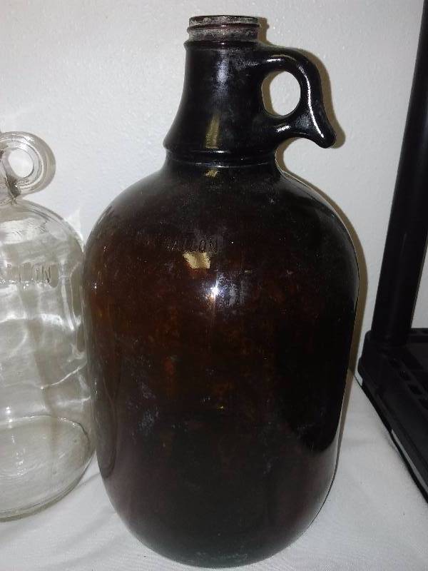 lot 89 image: Vintage Glass Bottle 1-gallon Brown Jug, Marti Gra