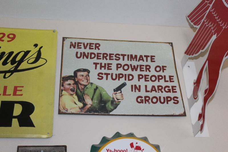 lot 64 image: Never Underestimate The Power Of Stupid People In Large Groups Metal Sign