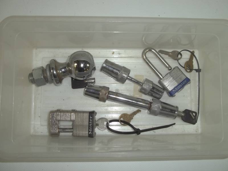 lot 20 image: 3 trailer locks, 1 regular lock, and a 1- 78 ball.  Keys included.