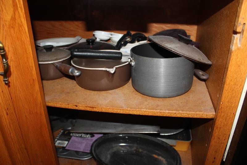 lot 184 image: Contents of Cupboard Includes Pots and Pand w Lids, Cooking Sheets, Bakers Pans, And More