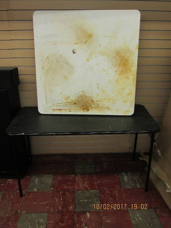 2 folding tables, one has a dirty t...