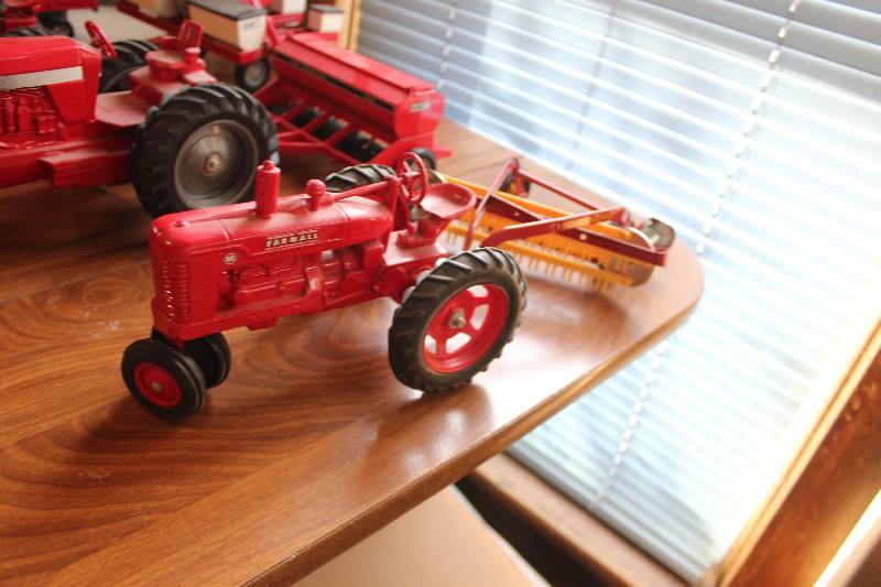 lot 598 image: McCormick Deering Farmall M Toy Tractor w Pull-Behind Farm Implement