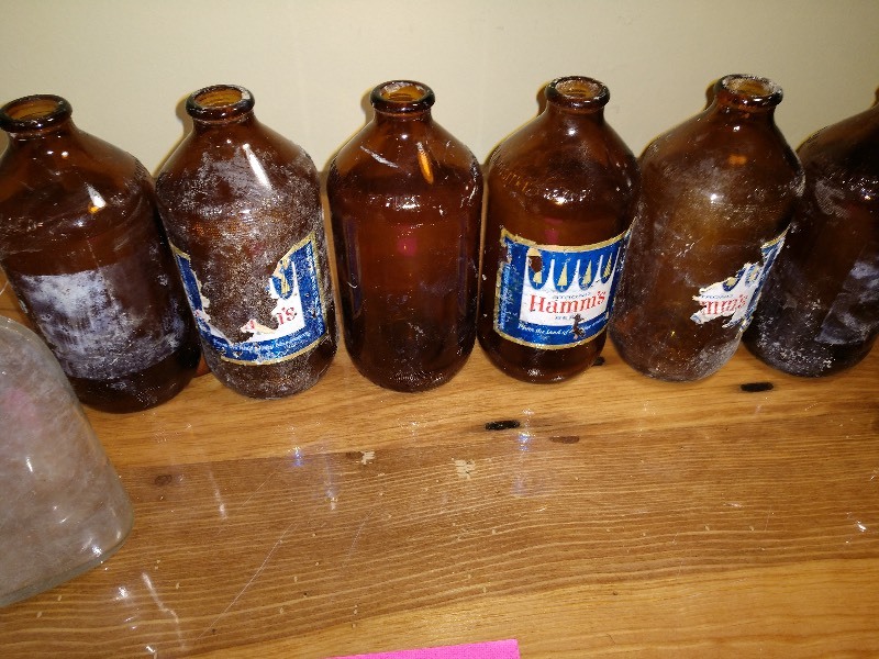 lot 58 image: HAMMs Glass Bottles, Schmitt Gold Label Can, Vintage Whiskey Bottle, and Misc. Cans and Bottles