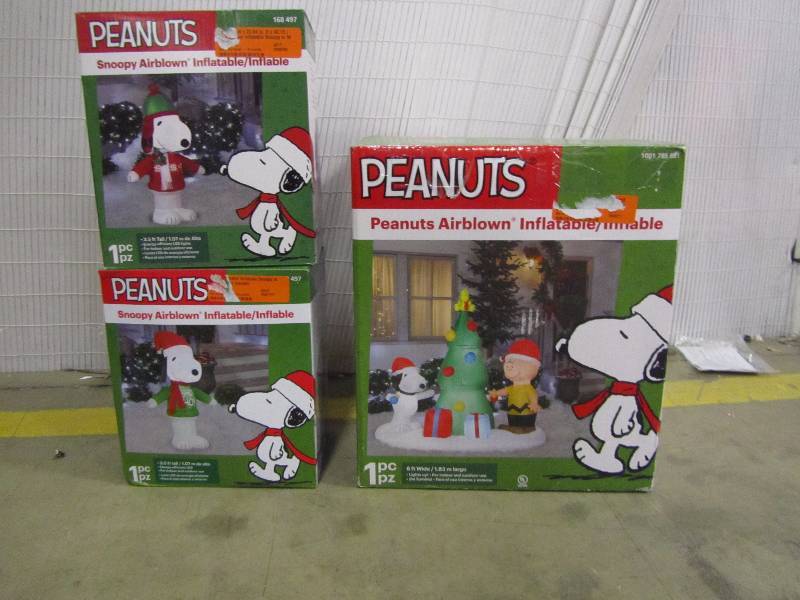 lot 23 image: Home Accents Holiday 6 ft. Lighted Inflatable Snoopy and Charlie Brown with Christmas Tree Scene 23.62 in. W x 22.84 in. D x 42.13 in. H Lighted Inflatable Snoopy in Winter Wear42 in. Inflatable Airblown Snoopy with Ho Ho Ho Sweater
