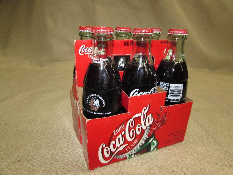 lot 134 image: COCA - COLA BOTTLES AND 6 PACK CARDBOARD CARRY PACK, FIGHTING SIOUX