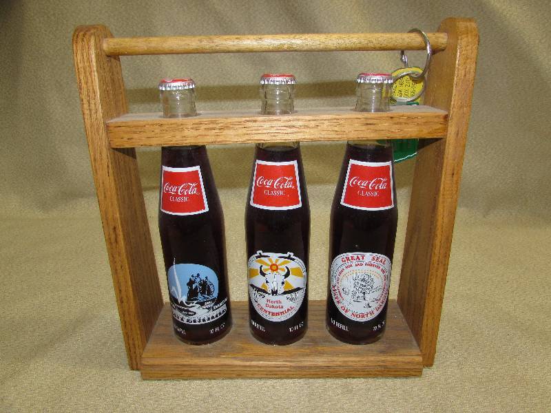lot 156 image: NORTH DAKOTA CENTENNIAL COKE BOTTLE SET IN WOODEN CRATE