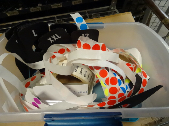 Bin of marking stickers. Clothes ra...