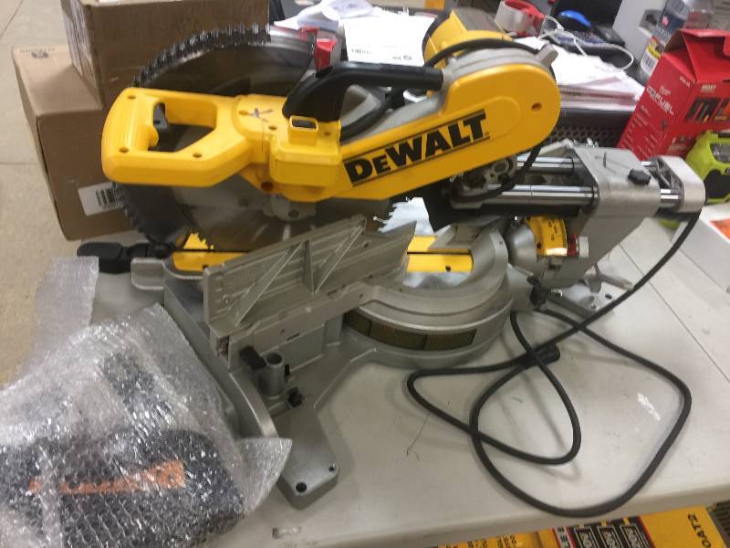 lot 107 image: DEWALT 15 Amp 12 in. Double Bevel Sliding Compound Miter Saw Model # DWS780 in like New conditions