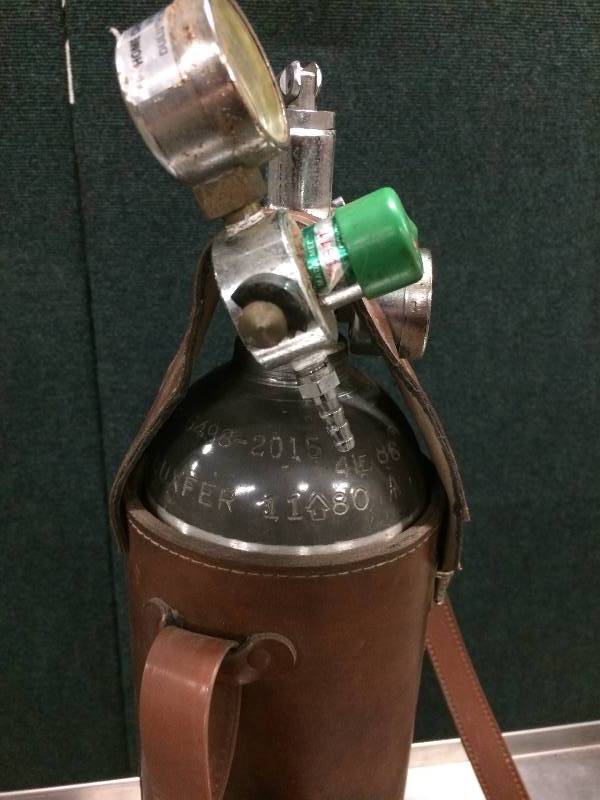 lot 9 image: Medical Oxygen Tank With Regulator Mada Leather Carrying Case. Includes oxygen level meter and flow meter. In good working condition.