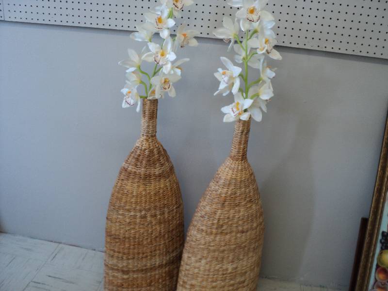 lot 8 image: Flower arrangements in wicker vases...