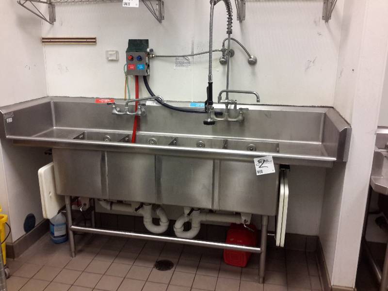 lot 2 image: 4 Section Stainless Steel Sink with 2 drainboards and sprayer..  Soap Dispenser and 2 cutting board holders with cutting boards
