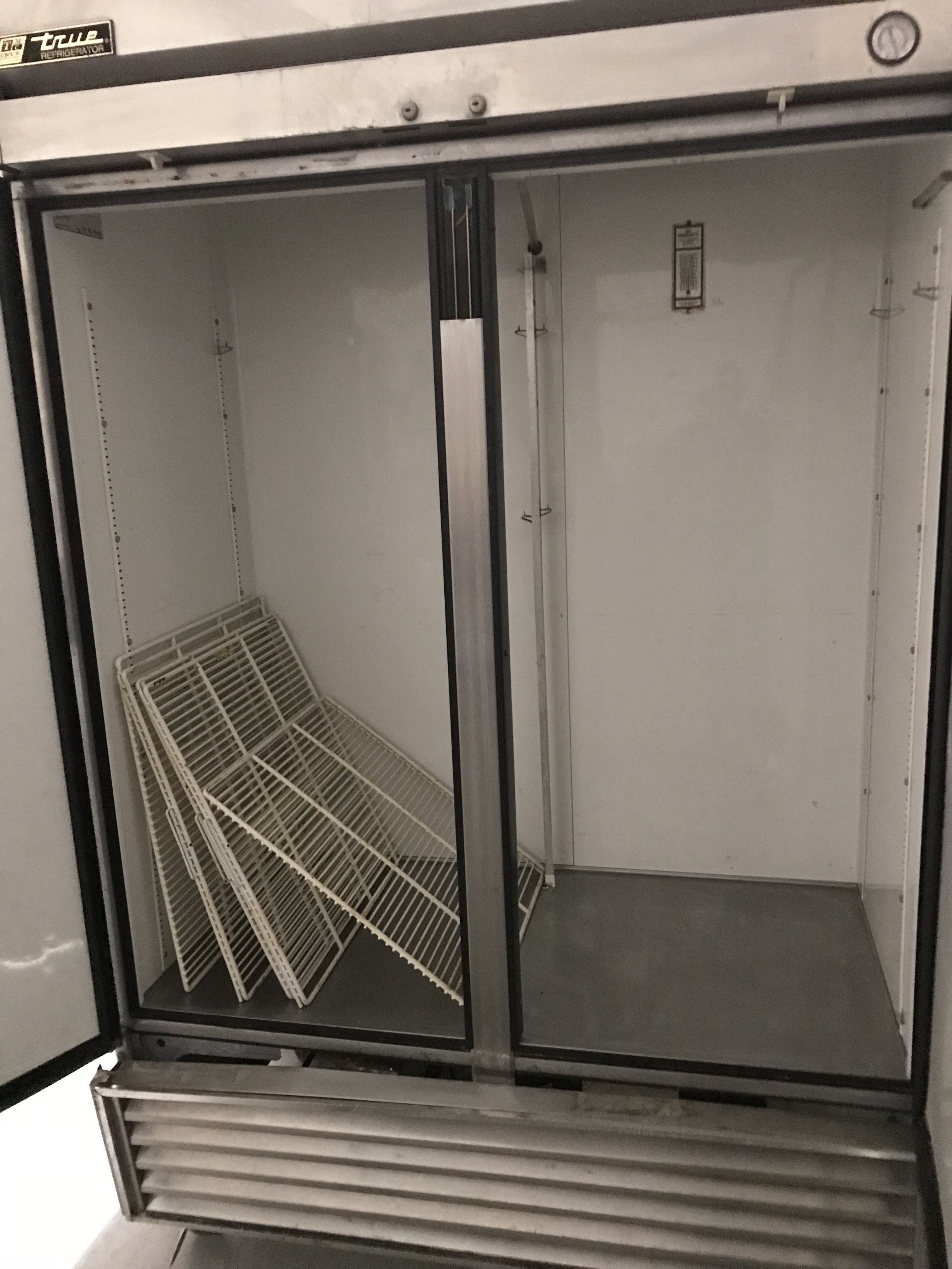 lot 15 image: True Double door stainless fridge on wheels. Runs Cools