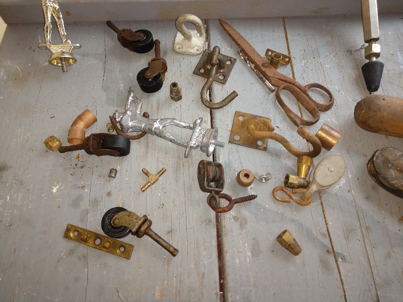 lot 83 image: Old Trophy Topper, Cast Iron Hooks, Cast Iron Pulleys, Casters, Scissors, 4 12 Window Weight, Hastings Steel Vent Gauge, Drill Bit Holder, and Change Drawer