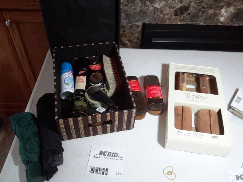 lot 157 image: Shoe polishing materials.. Polish, Brushes, Shoe Stretchers.. 2 umbrellas.. Nice basket to hold it all