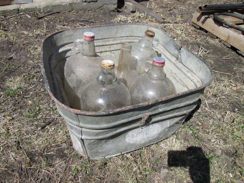 lot 75 image: metal tub with 5 glass gallon jugs...