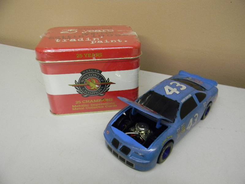 lot 58 image: Bobby Hamilton #43 STP 25th Anniversary 1972 Winston Cup NASCAR Action 124 Bank - NASCAR WINSTON CUP CHAMPIONS 25 CHAMPIONS METALLIC IMPRESSIONS METAL COLLECTOR CARDS. NEVER OPENED - SEE PICTURES