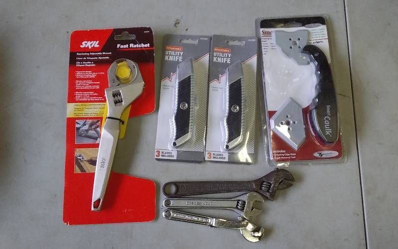 lot 25 image: New Skil Fast Ratchet, 2 New Utility Knives, 6 & 8 Inch Adjustable Wrenches, 6 Inch Auto Mat Wrench, Caulking Tool