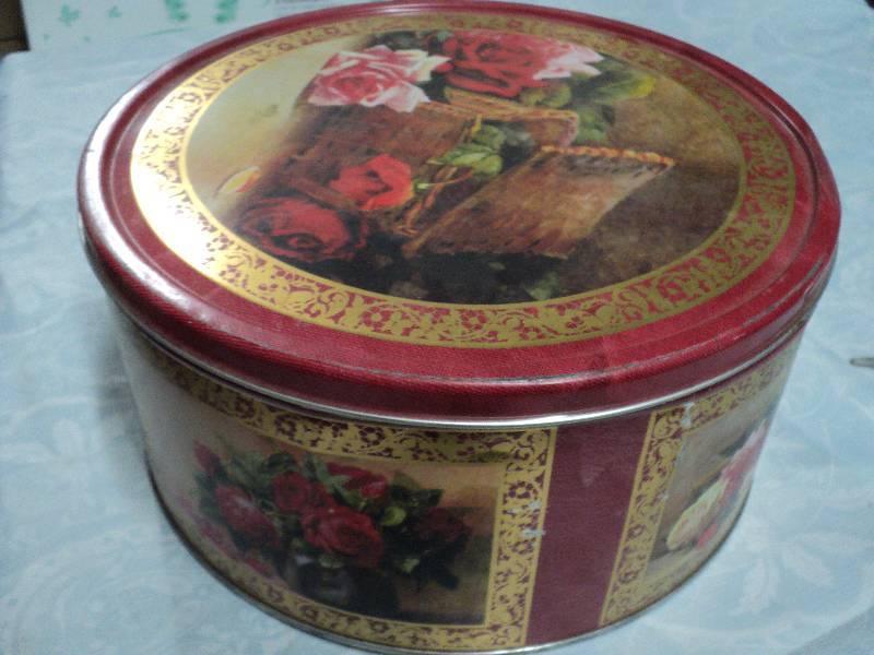 lot 38 image: round vintage tin with cover filled...