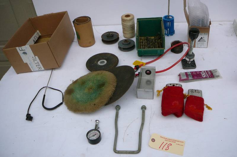 lot 118 image: Lot of drill bits, hand warmers, rechargeable battery, grinding wheel, spare tire mount, tire gauge, buffing pad
