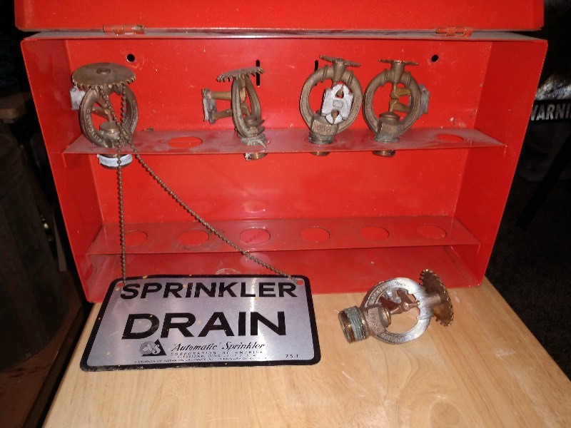 lot 7 image: Red Case Containing Sprinkler Heads and Sprinkler Drain Hang Sign