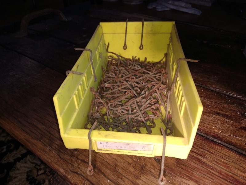lot 72 image: Grey Stack and Nest Container, Pegboard Display Hooks, Yellow Polythylene Parts Bin, and Rusted Cabin Hooks