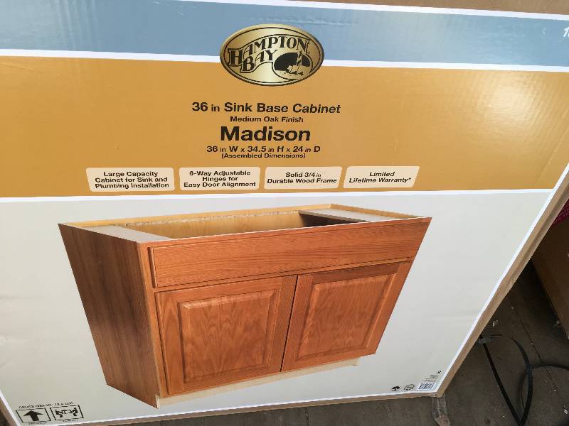 lot 15 image: Hampton Bay Madison Assembled 36x34.5x24 in. Sink Base Cabinet in Medium Oak  open box not used