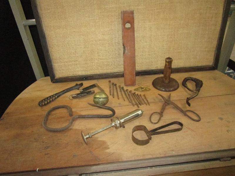 lot 123 image: Antique toolds- pig scrapper, pocket knifes, old belt buckle, bell, old level, curry comb, bale hook