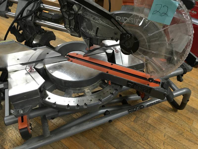 lot 22 image: RIDGID 15 Amp 12 in. Corded Dual Bevel Sliding Miter Saw with 70° Miter Capacity whit folding stand  USED in working conditions