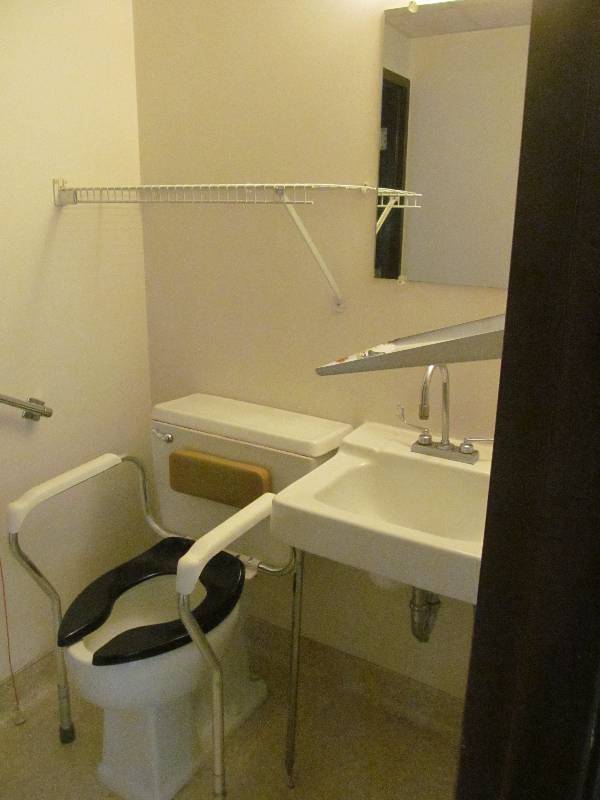 lot 109 image: (Rm 42) Bathroom, toilet, sink, dispenser, wire shelf, mirror
